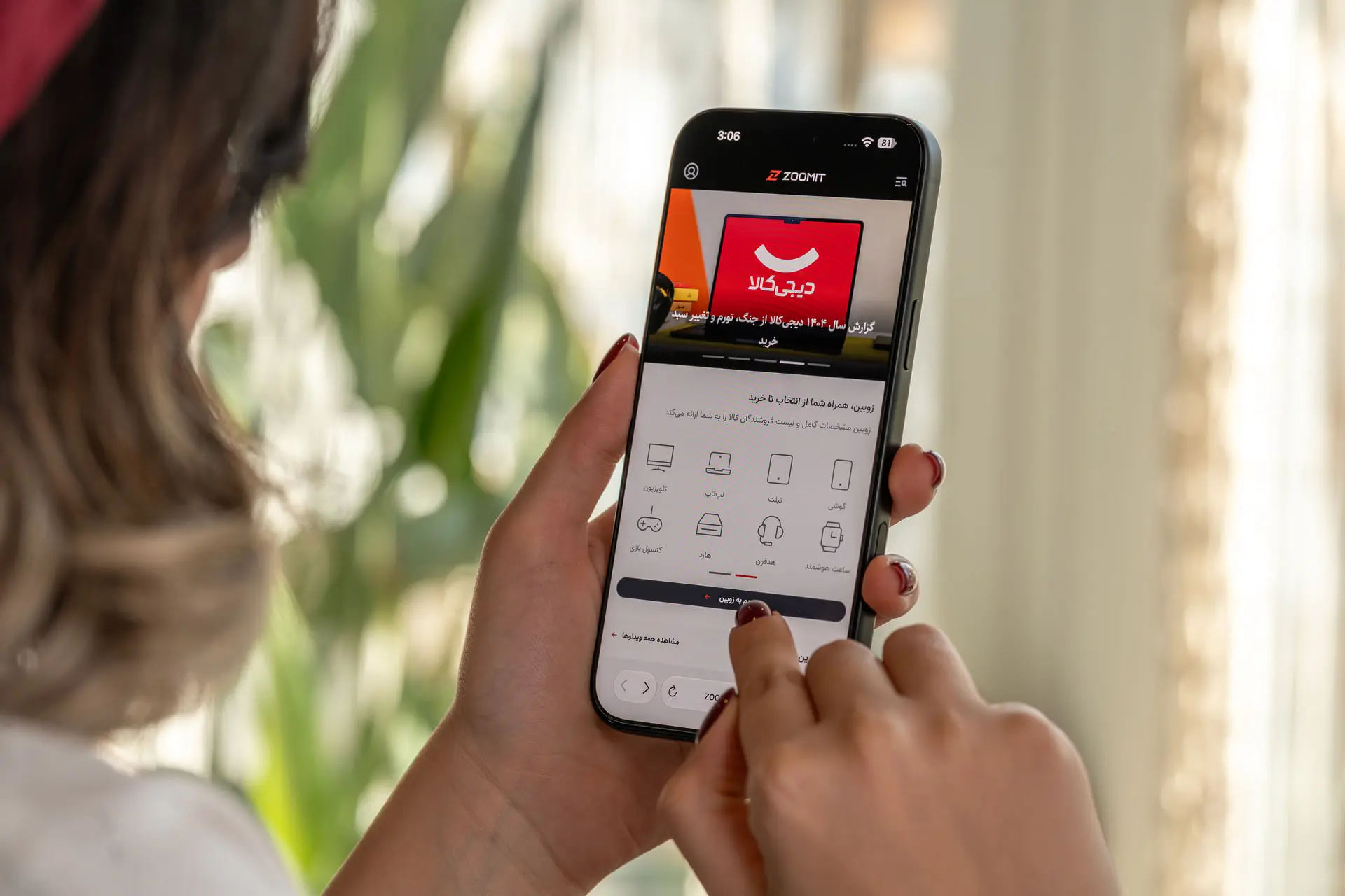 نمای نزدیک از دستان کاربر در حال کار با اپلیکیشن زومیت (Zoomit) در گوشی هوشمند