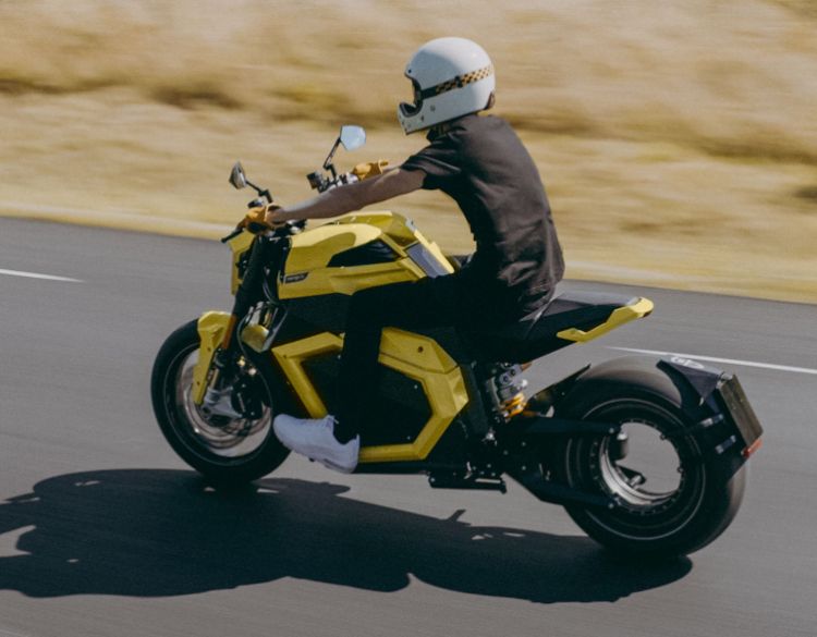 A yellow ts ultra verge motorcycle that someone drives on the road