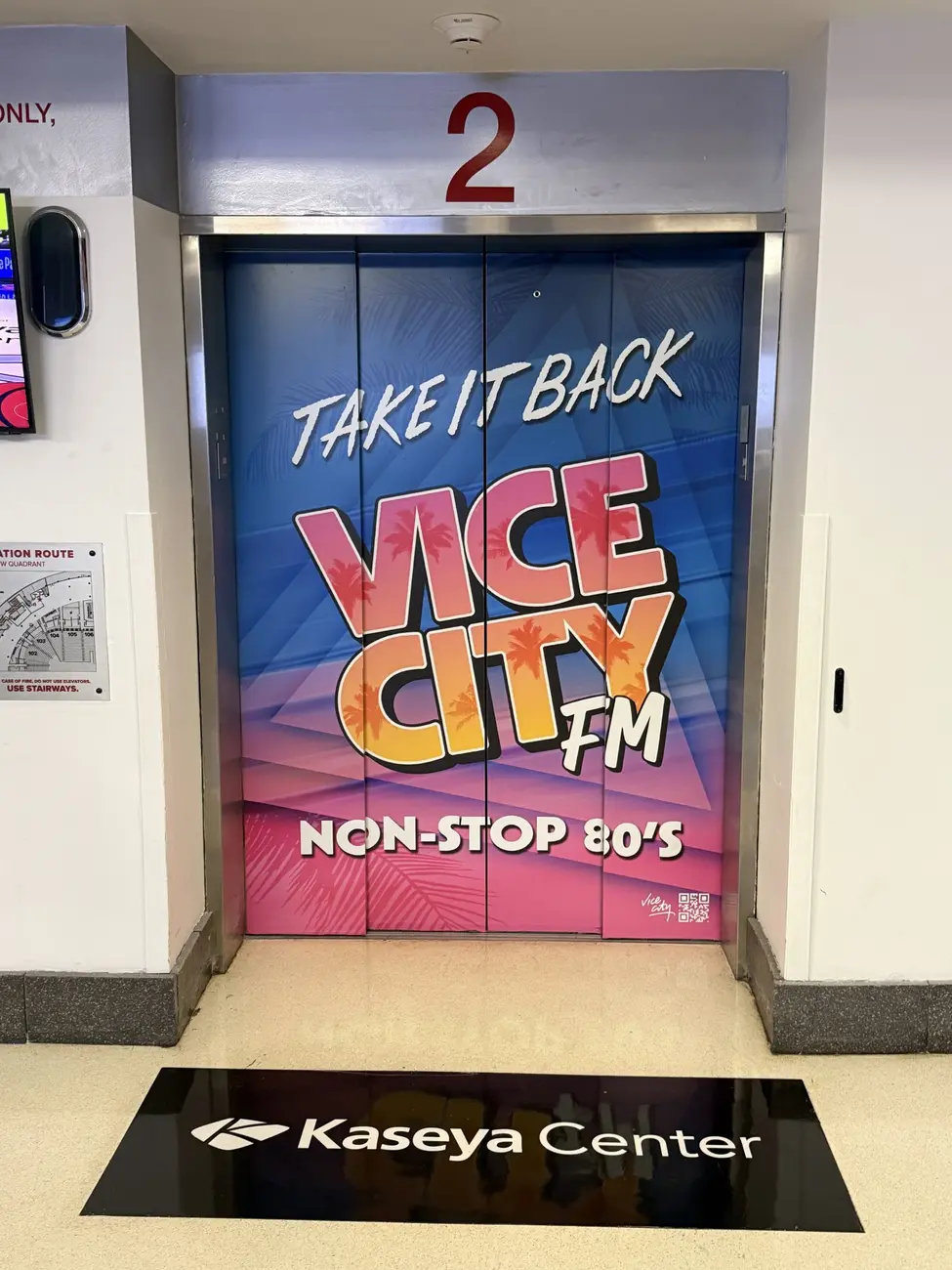 درهای آسانسور با گرافیک رنگی و نوشته‌های ایستگاه رادیویی وایس سیتی (Vice City FM)