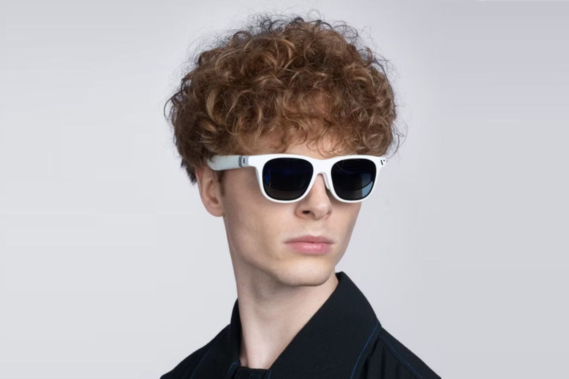 عینک واقعیت افزوده Vitrue Pro روی صورت مرد جوان با موهای فر