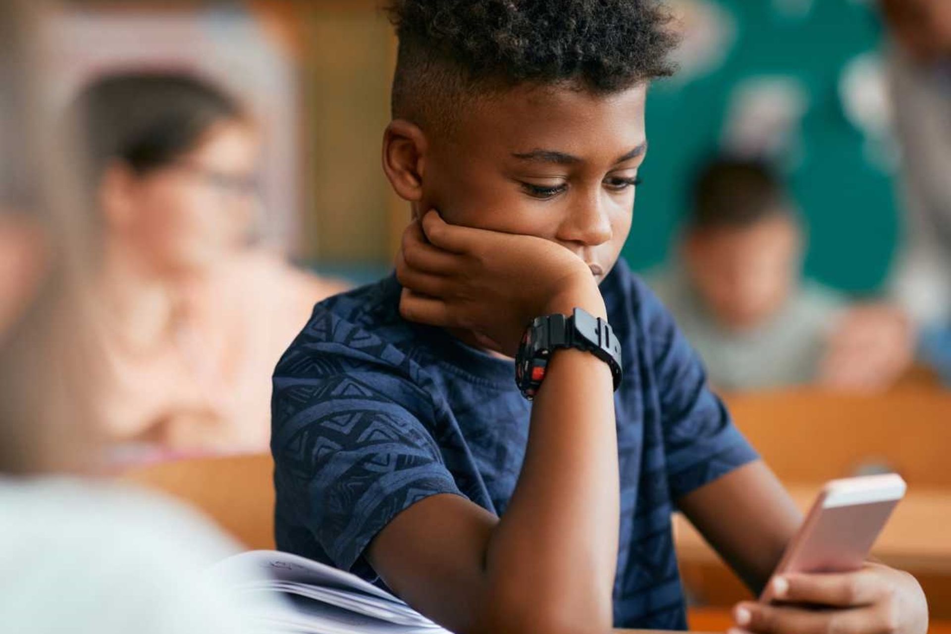 پسر نوجوان درحال کارکردن با تلفن همراه خود است