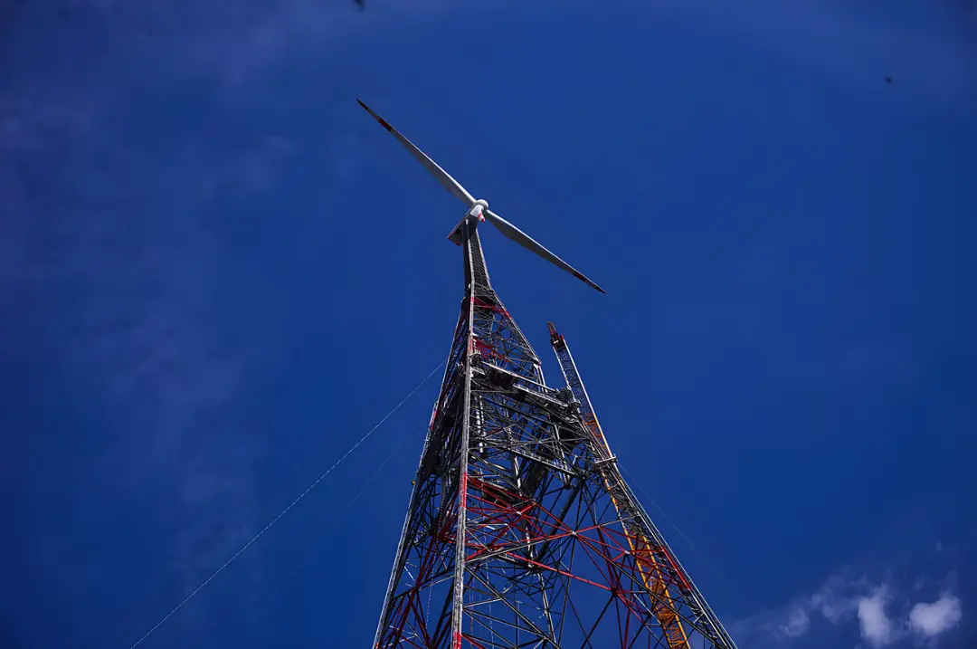 توربین بادی (Wind Turbine) روی یک دکل فلزی مشبک در آسمان