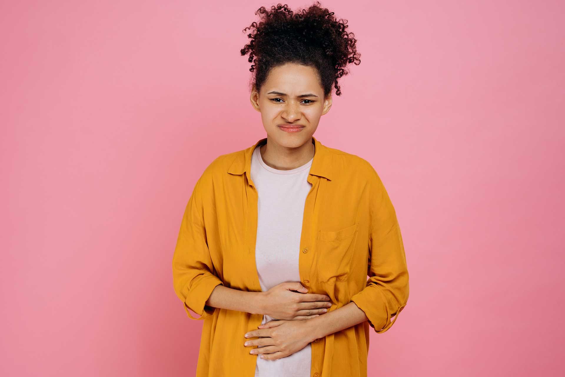 زن جوان دستانش را روی شکمش قرار داده است