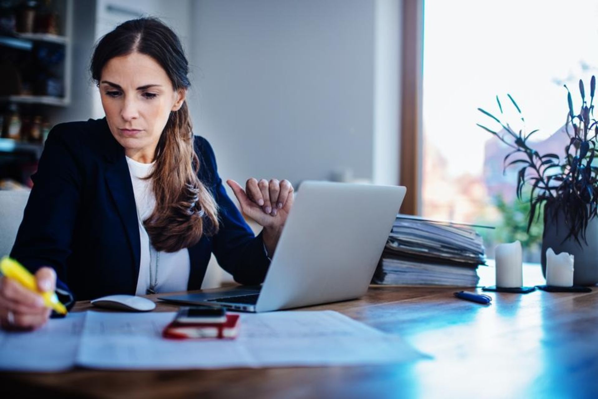 یک زن میان‌سال در حال کارکردن پشت میز