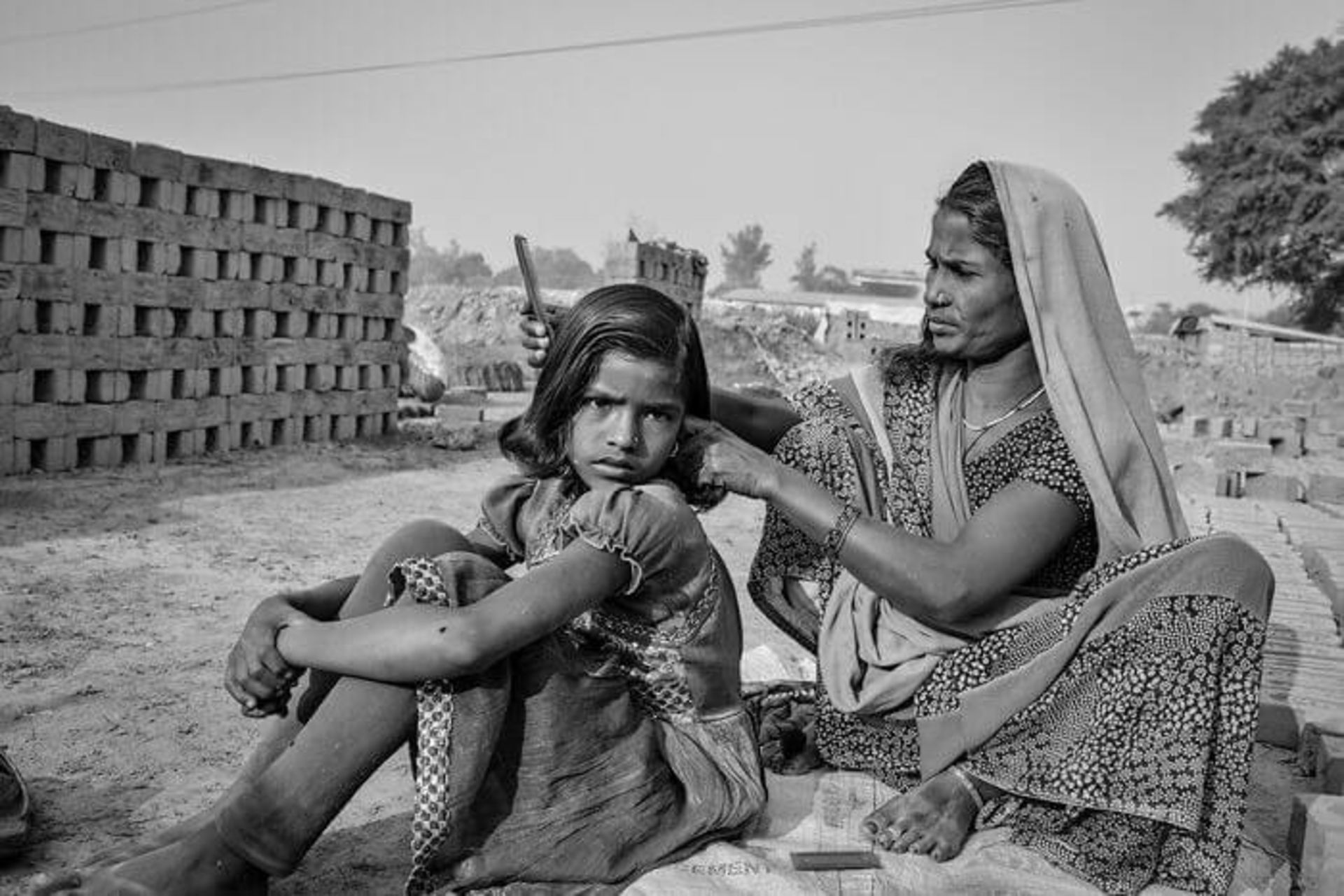 مادری در حال شانه کردن موهای فرزندش