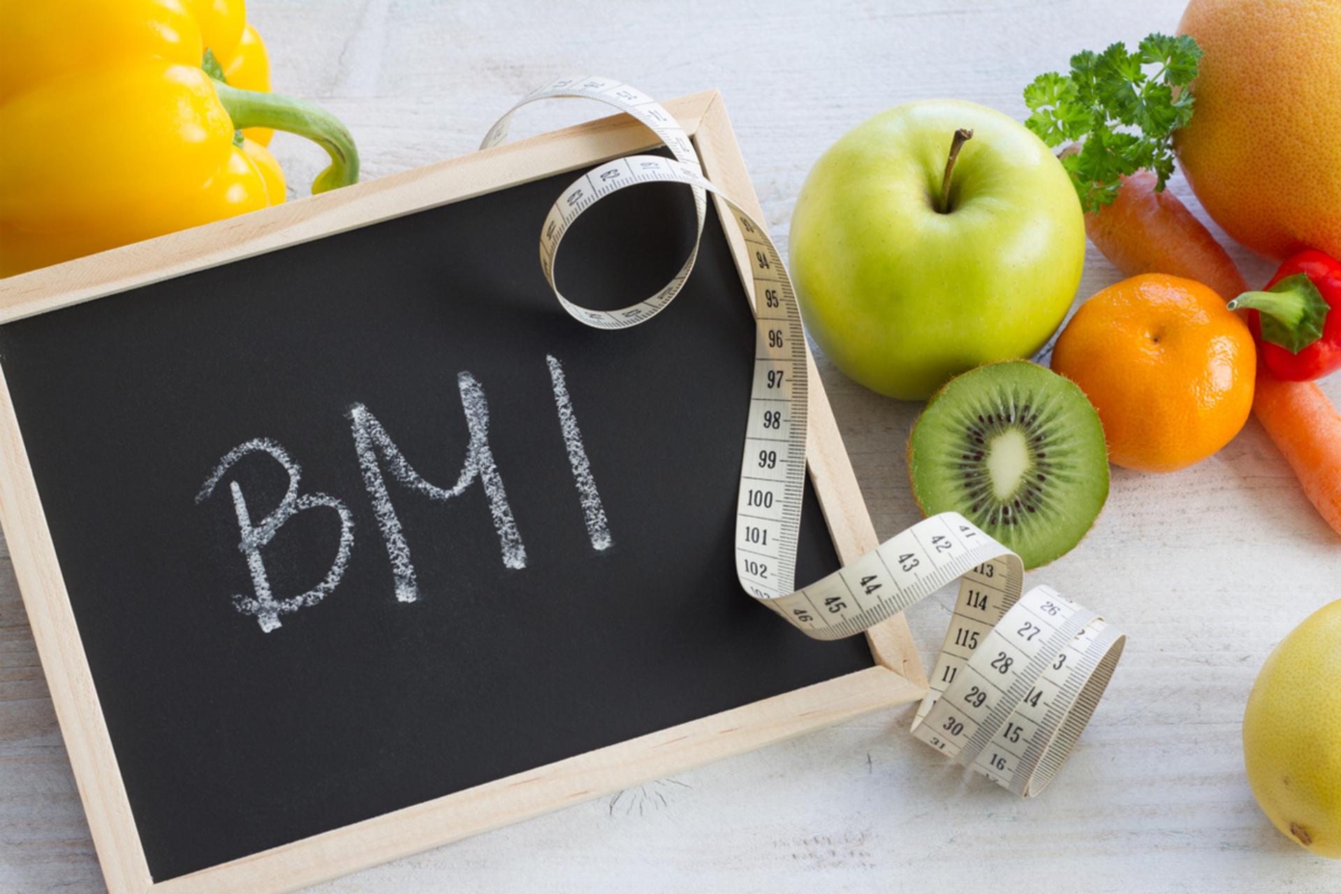 کلمه‌ی BMI روی تخته‌ی سیاه همراه میوه و سانتی‌متر