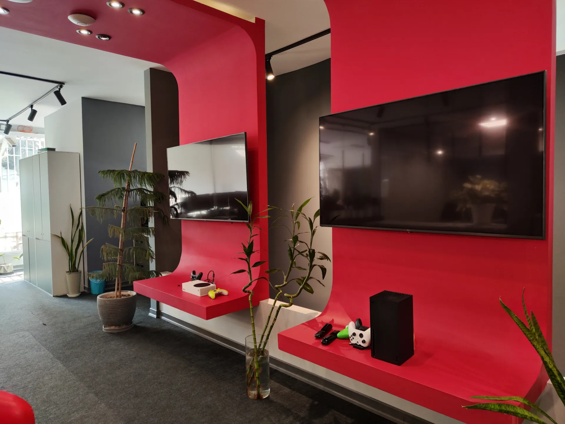 دو تلویزیون روی دیوار قرمز در دفتر