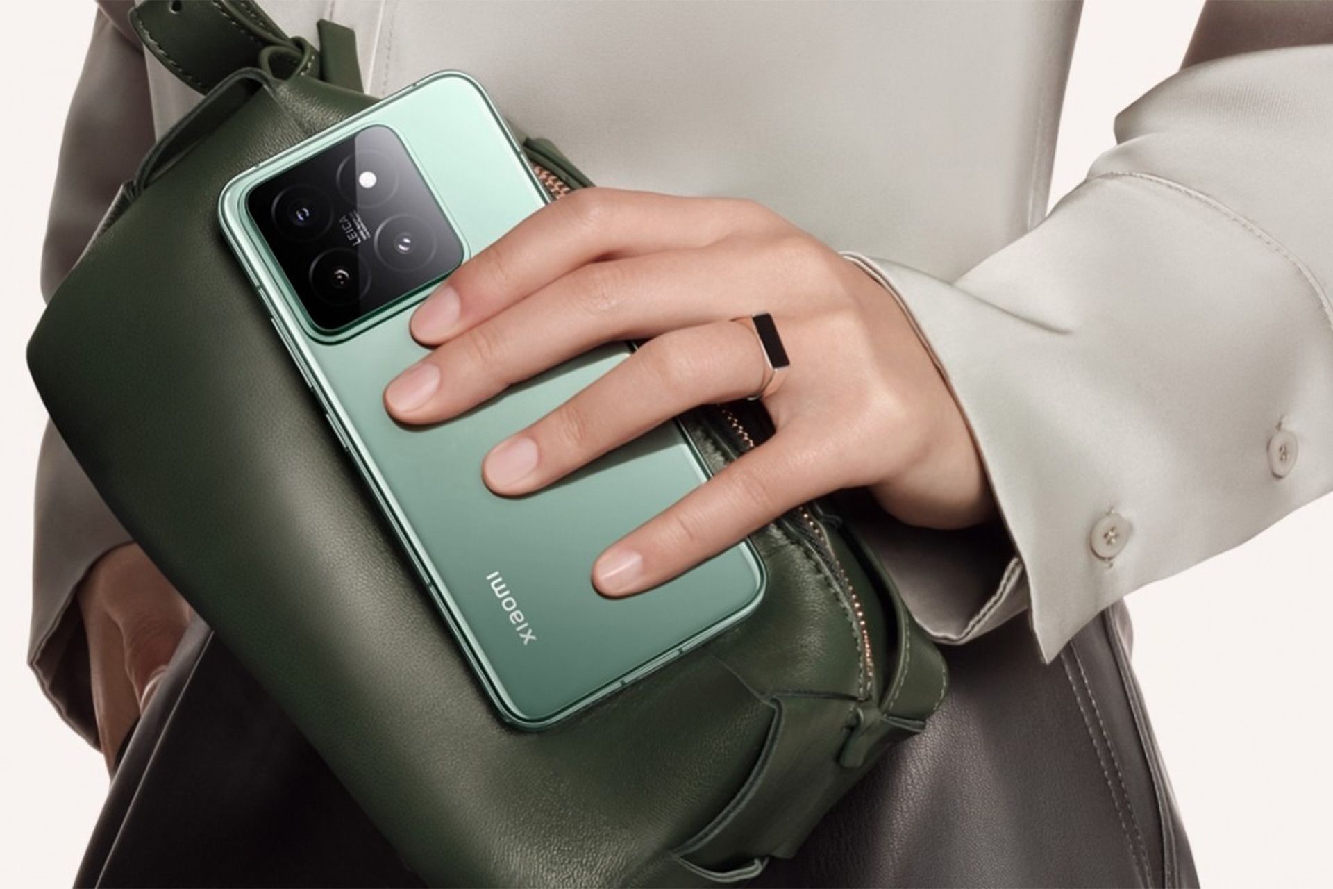 نمایش پنل پشتی گوشی شیائومی ۱۴ به رنگ سبز در دستان یک شخص