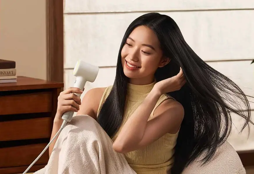 سشوار شیائومی میجیا (Xiaomi Mijia Hair Dryer Mini) در حال خشک کردن موهای بلند یک زن