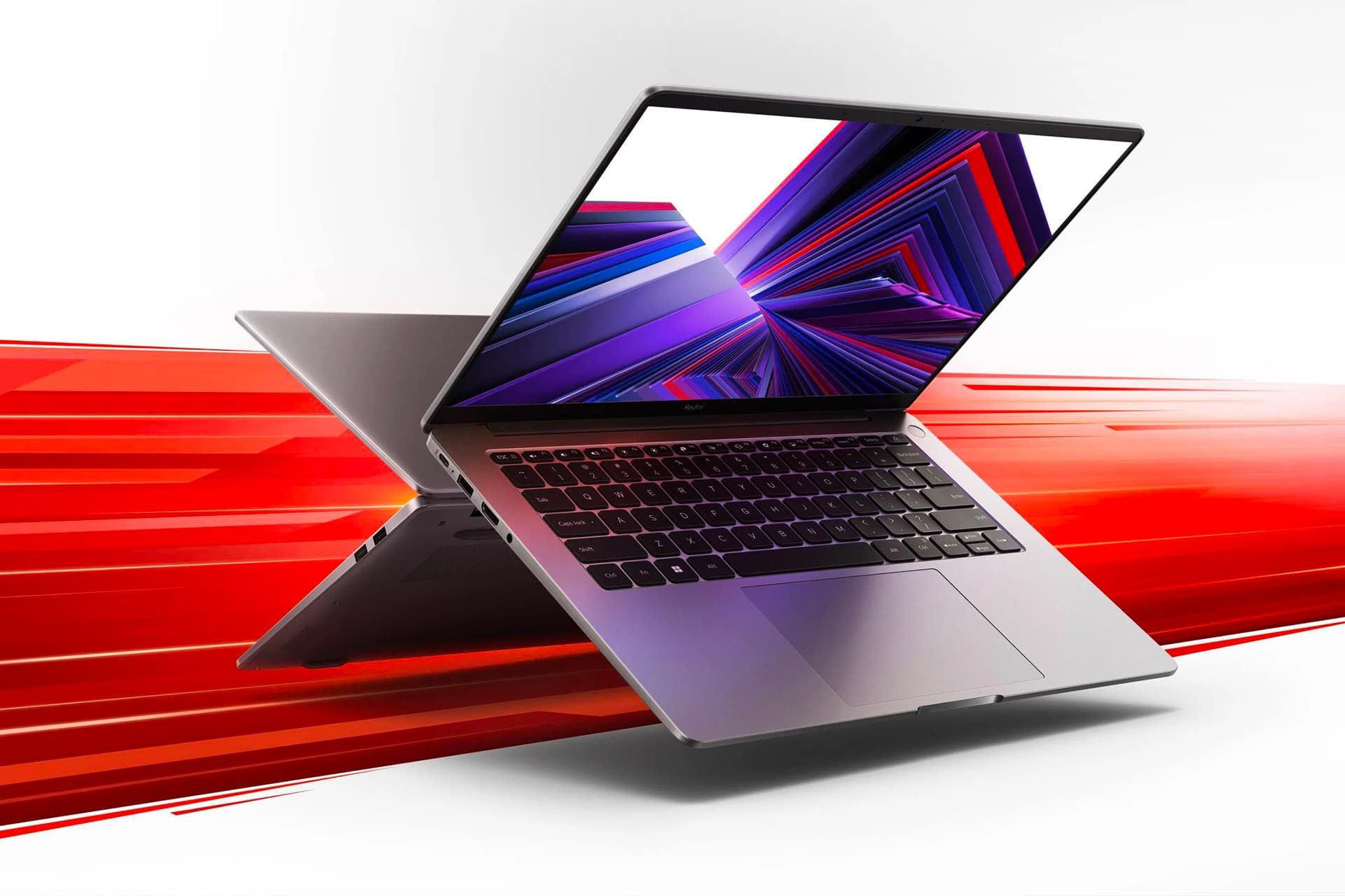 لپ تاپ ردمی بوک ۲۰۲۴ شیائومی در پس زمینه سفید قرمز