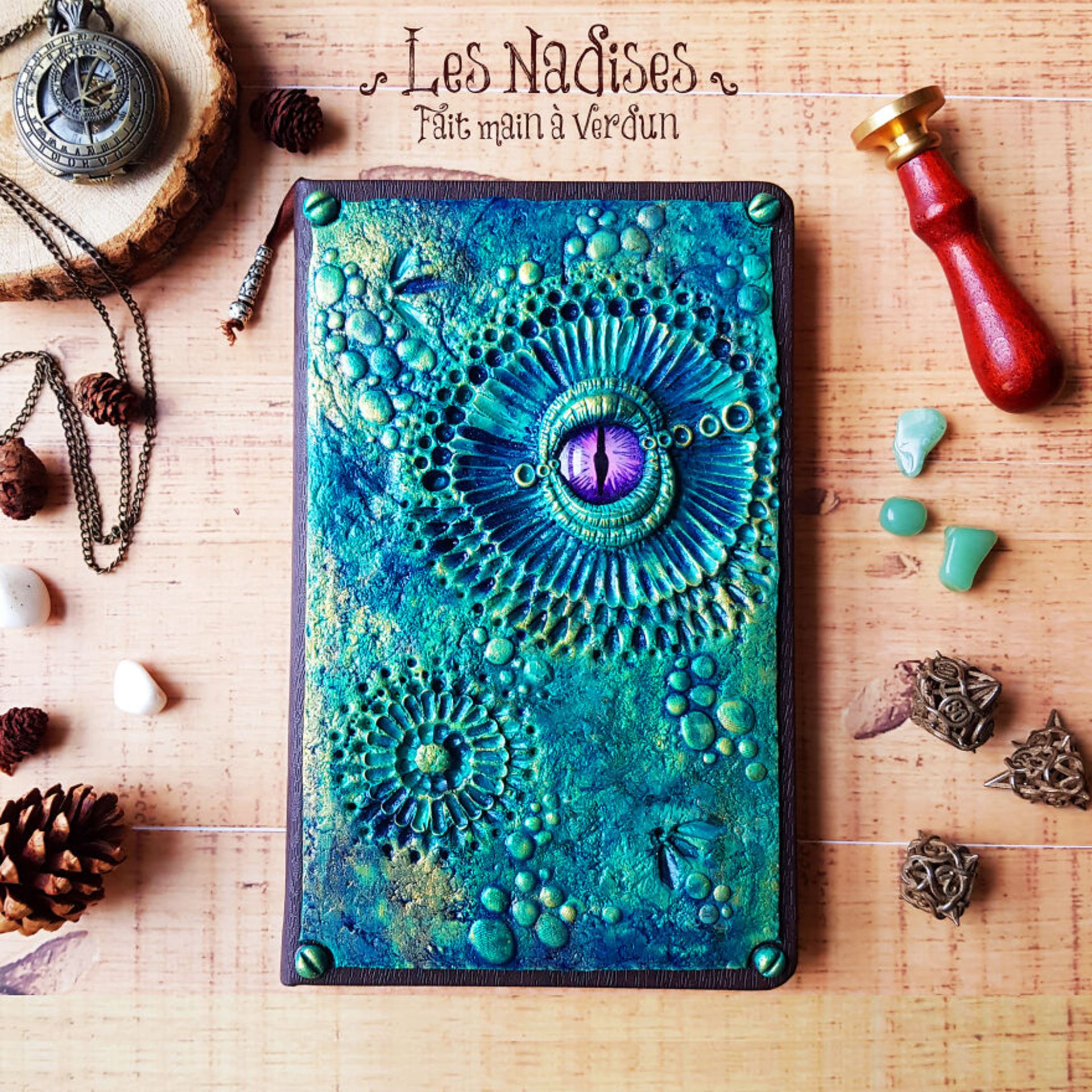 دفتر دست‌ساز سبز آبی با چشم اژدها بنفش