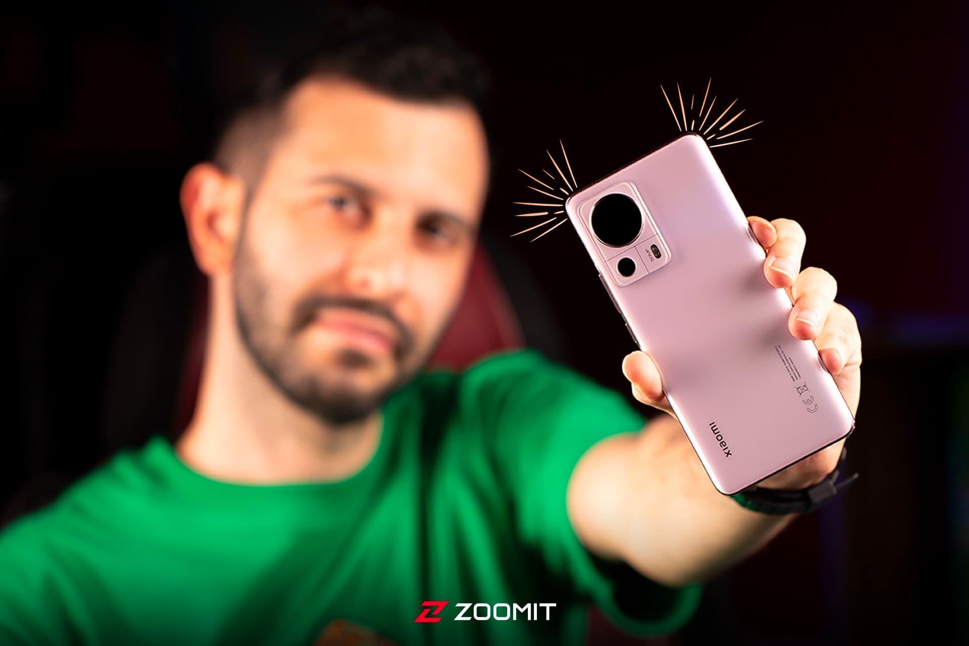 شیائومی ۱۳ لایت / Xiaomi 13 Lite در دست مرد جوان با لباس سبز