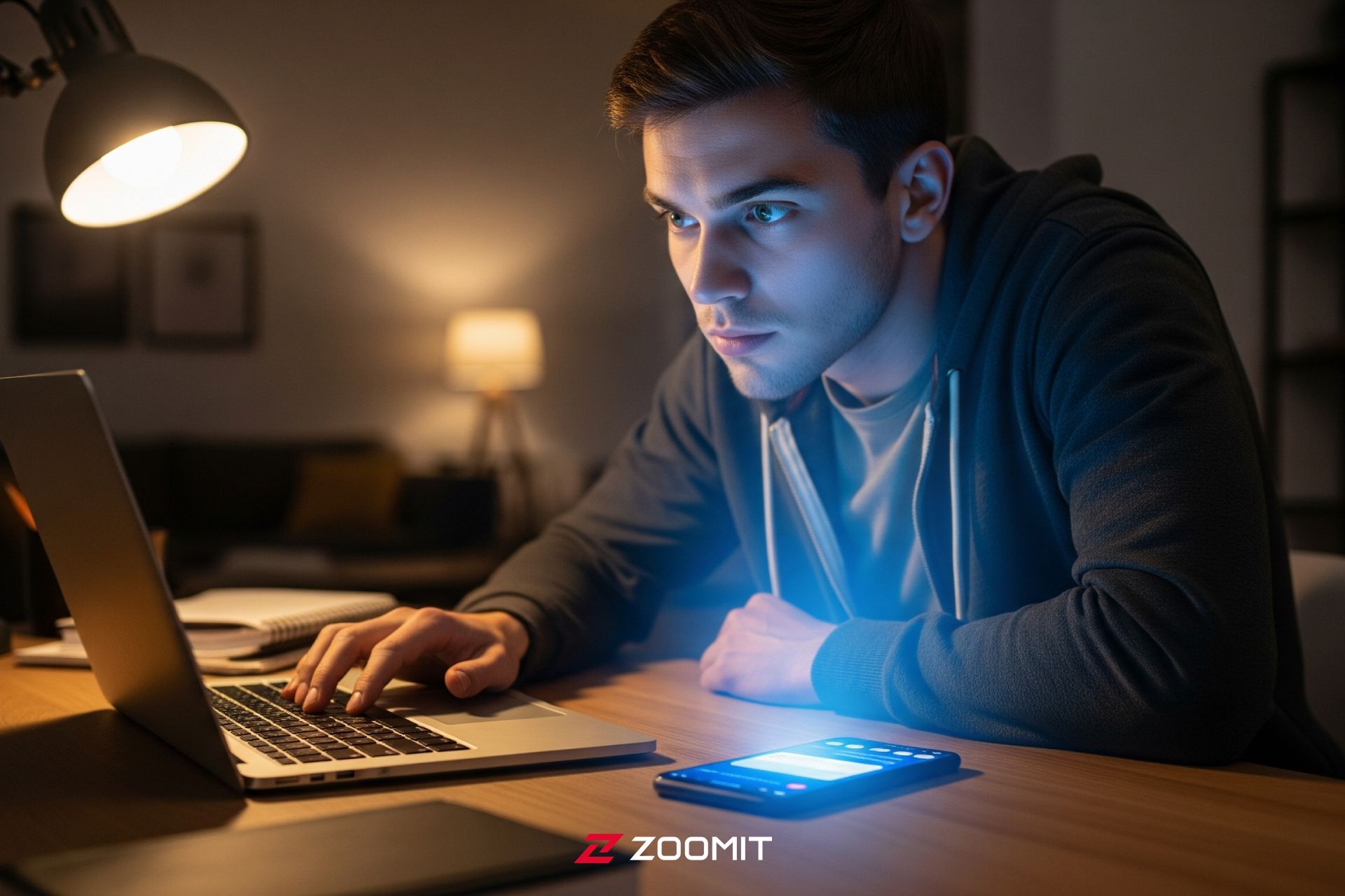 فرد جوان که پشت میز نشسته و عمیقاً روی کار متمرکز است، اما ناگهان حواسش به یک گوشی هوشمند درخشان که در نزدیکی‌اش قرار دارد، پرت می‌شود.