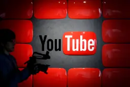 لوگوی یوتیوب (YouTube) در میان نمایشگرهای قرمز رنگ و یک فیلم‌بردار
